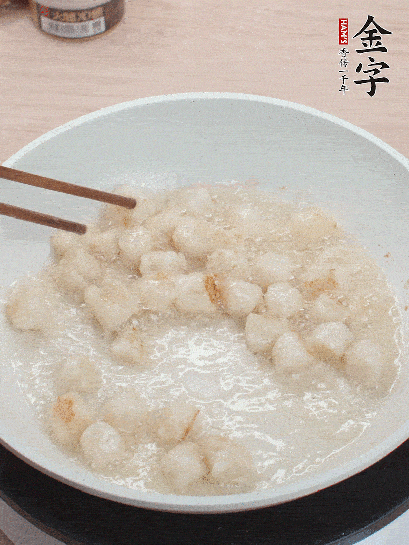 油溫4成熱，鮮貝蘸干淀粉下鍋煎，一面微黃后翻面。