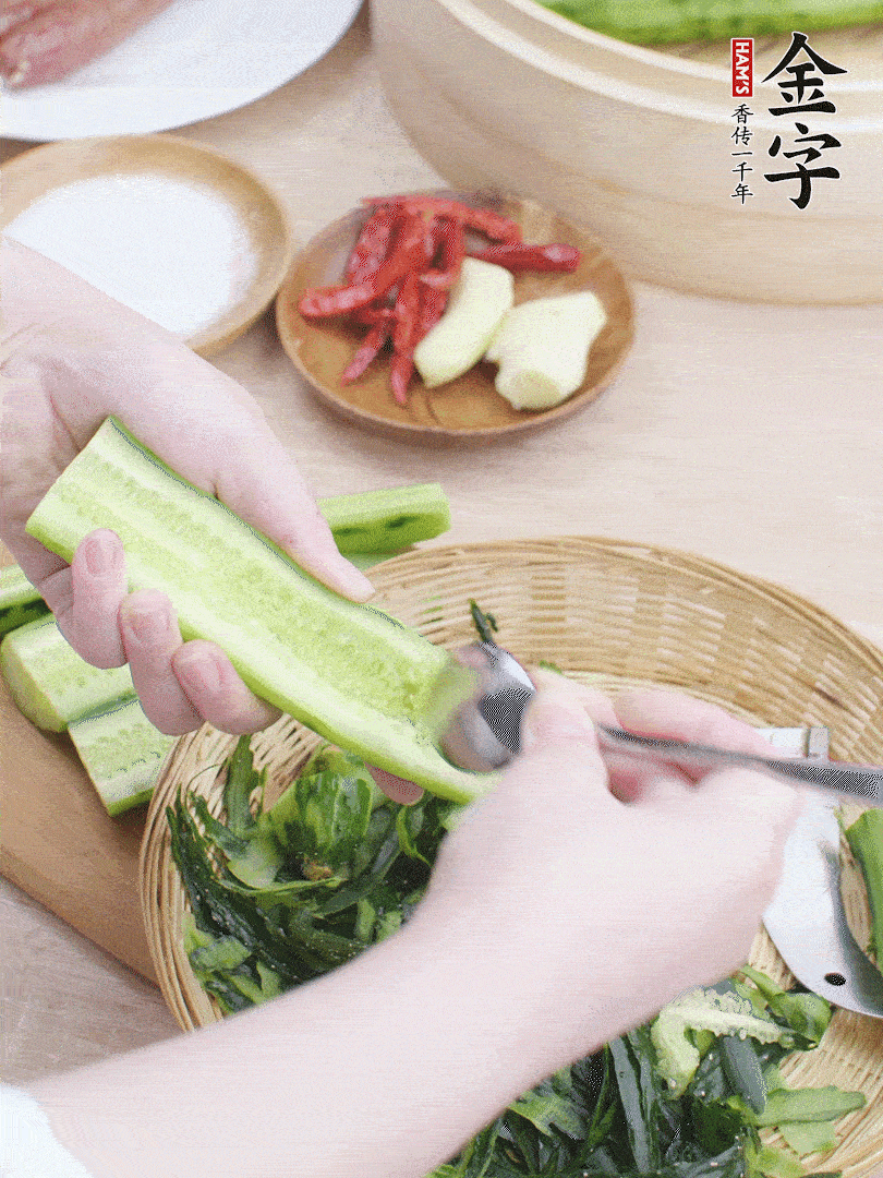 黃瓜削皮，對(duì)半切開，勺子挖去內(nèi)瓤，斜刀切片。青蒜斜刀切段。