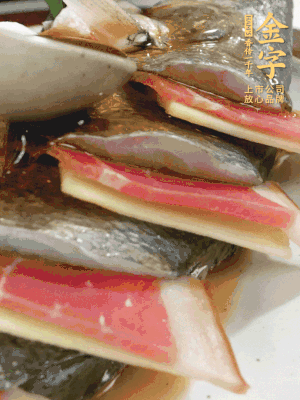 魚肚中塞蔥結、火腿片，魚身上碼放姜片、火腿片，倒入混合的料汁。