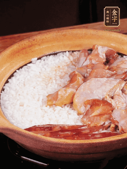 煮到椰子水微微收干轉(zhuǎn)小火，快速均勻鋪上雞肉、金字香腸