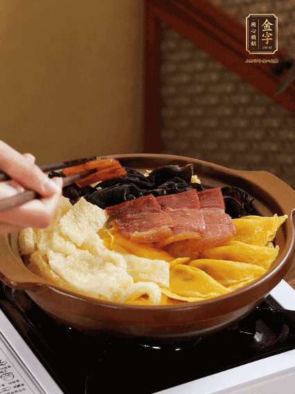 砂鍋底部鋪上娃娃菜，依次擺上肉皮、蛋餃、黑木耳、火腿